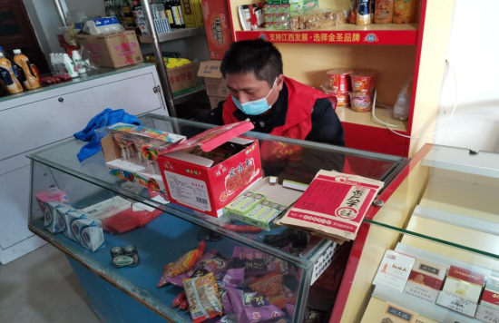 图为南昌县烟草专卖人员为困难客户整理柜台